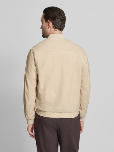 Mężczyzna nosi Jacke aus Baumwoll-Leinen-Mix mit Zweiwege-Reißverschluss von Jack & Jones Premium, beżowy kolor, krój regular fit, stójka, długość tyłu 68 cm, szerokość ramion 45 cm, szerokość w rozmiarze M 54 cm, długość rękawów 66 cm, gładka tekstura, mieszanka bawełny i lnu, widok całej sylwetki z tyłu.