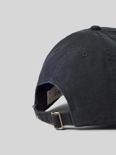 Produktfoto, Basecap mit Label-Stitching von Forét in dunklem Denim-Look mit Steppnähten und verstellbarem Riegel auf grauem Hintergrund.