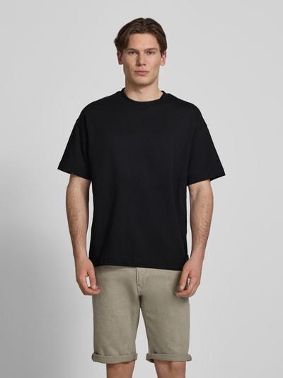 Mannenmodel draagt T-shirt met ronde hals model 'BARRON' van Jack & Jones in zwart, katoenmix met stretch, regular fit, voorkant volledig zichtbaar, ruglengte maat M: 69 cm.