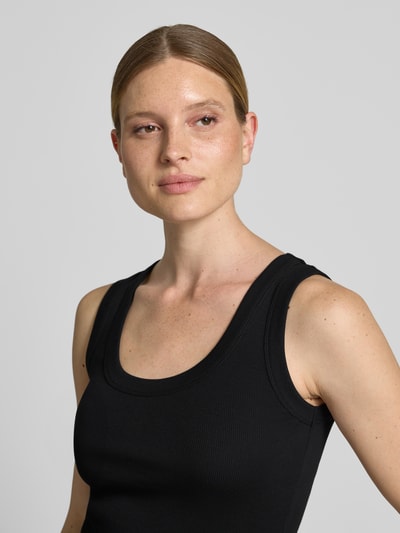 Modelka kobieca ma na sobie czarne Tanktop mit Rundhalsausschnitt Modell 'TAVIRA' od Drykorn z bawełny, krój slim fit, faktura prążkowana, zbliżenie na górną część ciała