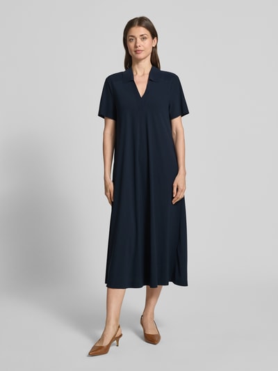 Frauenmodel trägt Midikleid mit Strukturmuster und Umlegekragen Modell 'JOSEPHINA' von Raffaello Rossi, dunkelblau, Ganzkörperansicht von vorne. Material-Mix mit Stretch-Anteil, lockerer Schnitt, V-Ausschnitt, kurze Ärmel.