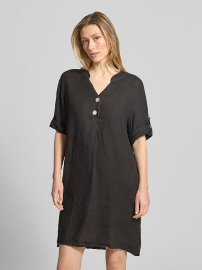 Frauenmodel trägt Tunikakleid aus Leinen mit V-Ausschnitt Modell 'Ki44ra' von ZABAIONE, Knopfleiste, Ärmel mit Aufschlag, Gerade, Reine Leinen, Rückenlänge 95 cm, Brustweite 50 cm, Ärmellänge 26 cm, Farbe Schwarz, leichte Textur, Ganzkörperansicht von vorne.