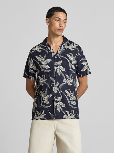 Männermodel trägt Regular Fit Freizeithemd mit Reverskragen von Superdry in Dunkelblau mit floralem Muster, reine Baumwolle, Ganzkörperansicht von vorne.