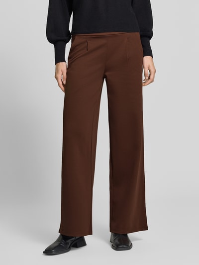 Frauenmodel trägt Wide Fit Hose mit Viskose-Anteil Modell 'Kate' von ICHI in Braun, vorne Eingrifftaschen, Nahaufnahme Oberkörper. Damen Hose, elastischer Material-Mix, Bundfalten, teilelastischer Bund, Bundweite 38 cm, Innenbeinlänge 80 cm.