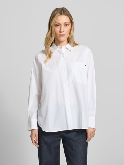 Frauenmodel trägt Regular Fit Langarmbluse aus reiner Baumwolle von Tommy Hilfiger, Optik: Unifarben, Logo-Stitching, Popeline, Ganzkörperansicht von vorne.