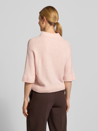 Frauenmodel trägt Strickshirt mit überschnittenen Schultern Modell 'Pafinna' von OPUS in zartem Rosa, weiche Textur, Material-Mix mit Mohair-Anteil, gerippte Abschlüsse, ganzkörperansicht Rückansicht.