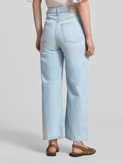 Frauenmodel trägt Straight Fit 7/8 Jeans von BOSS Orange in Denim-Optik, reine Baumwolle, Logo-Stitching, Knopf und verdeckter Reißverschluss, Ganzkörperansicht Rückansicht.