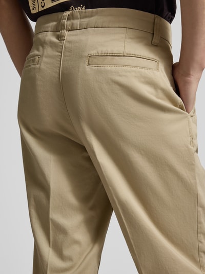Männermodel trägt Regular Fit Chino aus Baumwoll-Mix Modell 'TAAMIR PLEATED' von Armedangels, unifarben, Detailaufnahme Rückansicht.