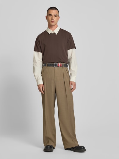 Männermodel trägt Ledergürtel aus echt leer von Diesel in zwart met labelprint, doornsluiting van metaal, used-look, wide fit, ganzkörperansicht von vorne.