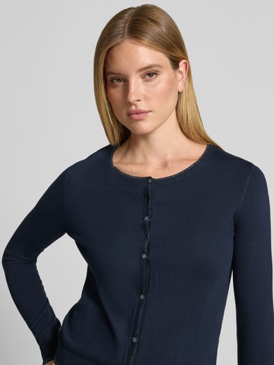 Modelka kobieca ma na sobie kardigan Slim Fit Cardigan aus Viskose-Mix Modell 'MAGLIA APERTA' od Liu Jo White, mieszanka wiskozy, krój slim fit, listwa guzikowa, długość tyłu w rozmiarze S: 53 cm, długość rękawów w rozmiarze S: 61 cm, ciemnoniebieski kolor, gładka tekstura, widok na górną część sylwetki, z przodu.