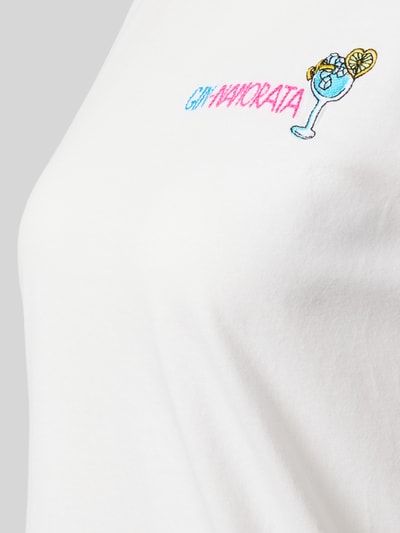 Frauenmodel trägt Damen T-Shirt mit Rundhalsausschnitt aus reiner Baumwolle, Motiv- und Statement-Stitching, Modell 'EMILIE' von MC2 Saint Barth, Nahaufnahme Oberkörper.