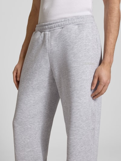 Männermodel trägt graue Sweatpants mit elastischem Bund von REVIEW, Relaxed-Fit aus Material-Mix mit Baumwoll-Anteil, Nahaufnahme Oberschenkel.
