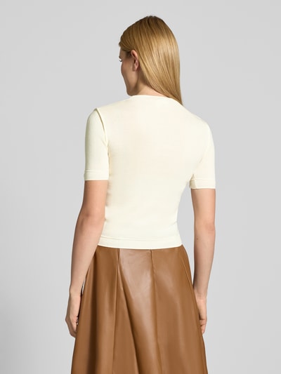Frauenmodel trägt Slim Fit Strickshirt mit Woll-Anteil Modell 'CAROLINE' von Guido Maria Kretschmer WOMAN, Material-Mix, Stehkragen, 1/2-Arm, Farbe Creme, kombiniert mit braunem Rock, glatte Textur, Ganzkörperansicht Rückansicht.