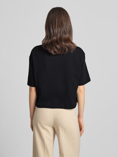 Frauenmodel trägt Boxy Fit T-Shirt mit Ziersteinbesatz von ARMANI EXCHANGE in Schwarz, reine Baumwolle, Rundhalsausschnitt, Ganzkörperansicht Rückansicht.