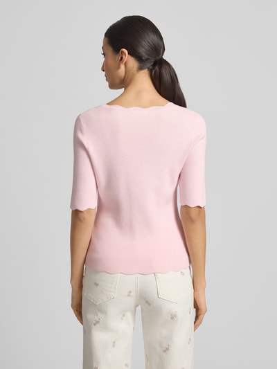 Modelka kobieca nosi Strickshirt aus Viskose-Mix mit Rüschenkragen od Christian Berg Woman w jasnoróżowym kolorze, dopasowany krój, falisty dół i rękawy 1/2, widok całej sylwetki od tyłu.