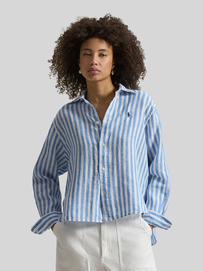 Frauenmodel trägt Boxy Fit Hemdbluse aus reinem Leinen von Polo Ralph Lauren mit blau-weißem Streifenmuster, Logo-Stitching, Ganzkörperansicht von vorne.