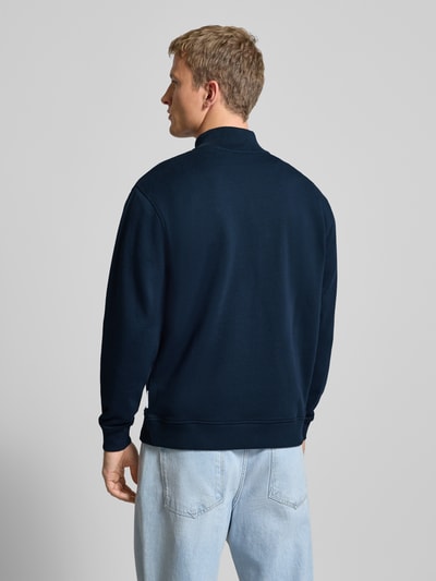 Männermodel trägt Regular Fit Troyer aus reiner Baumwolle von Marc O'Polo Denim in Dunkelblau, glatte Sweat-Textur, Ganzkörperansicht Rückansicht.