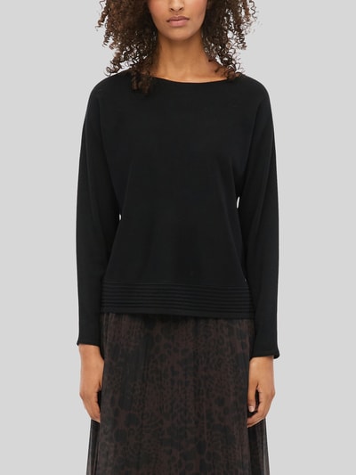 Frauenmodel trägt Relaxed Fit Pullover aus Viskose-Mix von s.Oliver BLACK LABEL in Schwarz, kombiniert mit Rock, Nahaufnahme Oberkörper.