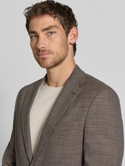 Männermodel trägt Slim Fit 2-Knopf-Sakko mit Pattentaschen von MCNEAL in Braun, feine Struktur, Reverskragen, Nahaufnahme Oberkörper