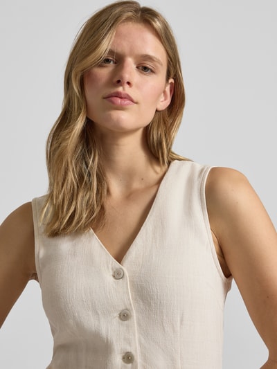 Frauenmodel trägt tailliertes Freizeitkleid aus Viskose-Leinen-Mix Modell 'SIESTA' von Only in Uni-Optik mit V-Ausschnitt, Knopfleiste, ärmellos, Flammgarn-Textur, Nahaufnahme Oberkörper.
