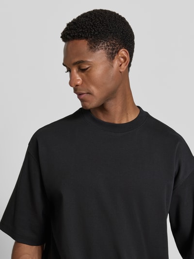 Männermodel trägt Relaxed Fit T-Shirt mit Rundhalsausschnitt von JAKE*S STUDIO MEN in Schwarz aus reiner Baumwolle, Nahaufnahme Oberkörper.