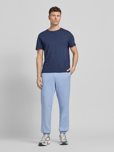 Männermodel trägt Regular Fit Sweatpants aus Baumwoll-Mix von Lacoste, unifarben, Logo-Stitching, elastische Bündchen, Ganzkörperansicht von vorne