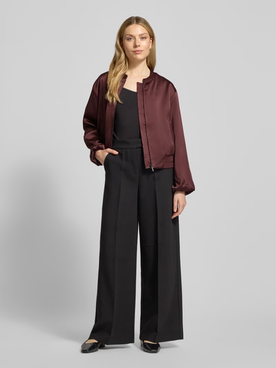 Modelka kobieca nosi bordowy Blouson mit Reißverschluss Modell 'Jupita' od OPUS, proste cięcie, okrągły dekolt, kieszenie boczne, całopostaciowy widok z przodu.