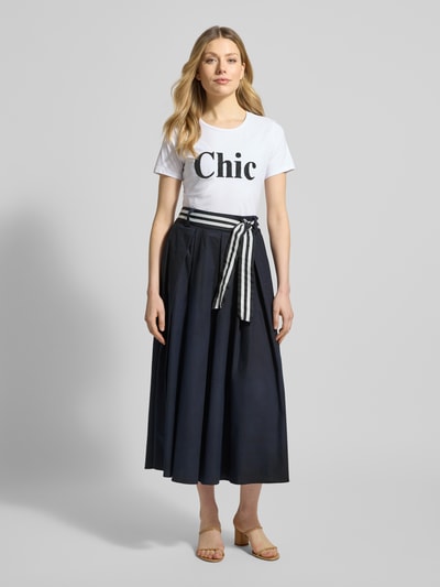 Frauenmodel trägt T-Shirt mit Rundhalsausschnitt und Perlen von More & More, Statement-Print, Weiß, Regular Fit, Ganzkörperansicht von vorne.