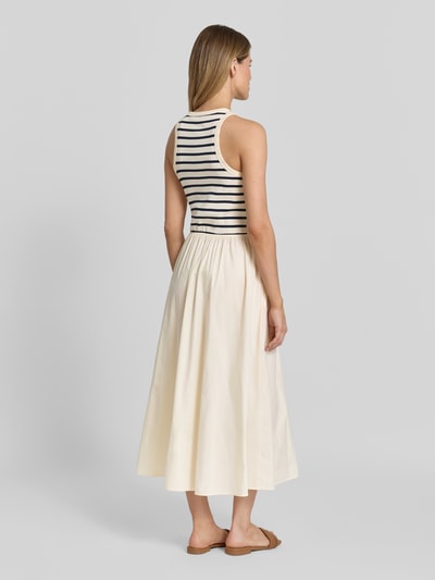 Frauenmodel trägt A-Linie Freizeitkleid aus reiner Baumwolle von Tommy Hilfiger in Creme und Dunkelblau, Ganzkörperansicht Rückansicht.