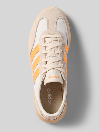 Produktfoto, Sneakersy mit Schnürverschluss von adidas Sportswear, mieszanka skóry, zaokrąglony czubek, detal z logo, fakturowana podeszwa, wysokość obcasa 4 cm, wysokość cholewki 7 cm, szerokość cholewki 6 cm, beżowy i pomarańczowy kolor, gładkie i matowe powierzchnie.