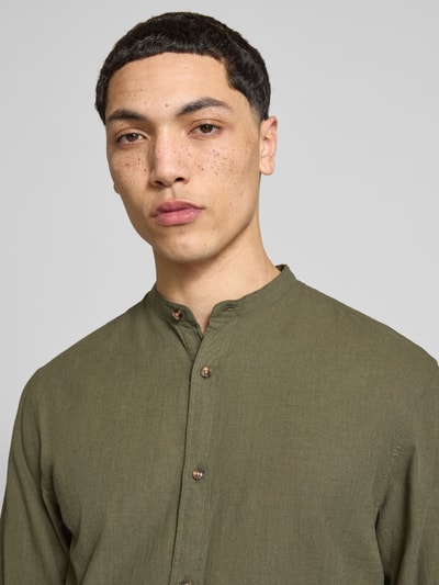 Männermodel trägt Regular Fit Freizeithemd aus Baumwoll-Leinen-Mix von Jack & Jones, Stehkragen, olivgrün, Nahaufnahme Oberkörper.