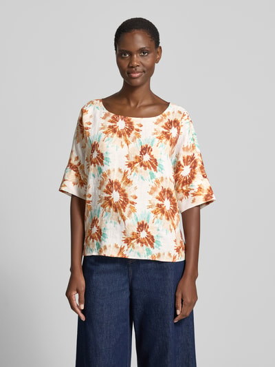 Frauenmodel trägt Bluse aus Leinen mit U-Boot-Ausschnitt von Christian Berg Woman, geblümtes Muster in Creme, Orange, Türkis, Loose Fit, Ganzkörperansicht von vorne.