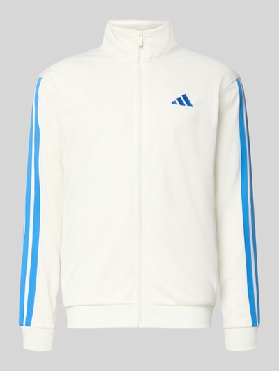 Produktfoto, Regular Fit Trainingsjacke mit Stehkragen von adidas Sportswear, Optik: Unifarben in Weiß mit blauen Kontraststreifen, Logo-Print, Verschluss: Reißverschluss, Ärmelform: Langarm, Ärmelabschluss: Elastisch, Rumpfabschluss: Elastisch, seitliche Eingrifftaschen