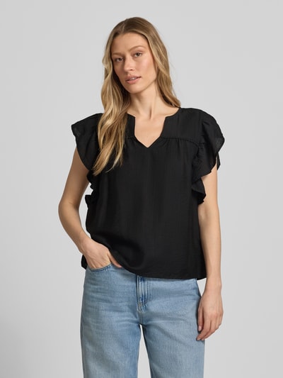 Kobiece model prezentuje bluzkę Bluse aus Viskose-Mix mit Rüschen Modell 'HETTA' od ICHI, czarna mieszanka wiskozy, prosty krój, dekolt serafino, falbany; długość tyłu 55 cm, długość rękawów 10 cm w rozmiarze 36, przód w pełnej sylwetce.