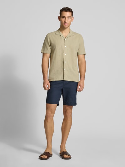 Männermodel trägt Relaxed Fit Freizeithemd aus Leinen-Baumwoll-Mix von Lindbergh, Reverskragen, Knopfleiste, Ganzkörperansicht von vorne. Rückenlänge bei Größe M 76 cm, Schulterbreite 47 cm, Ärmellänge 25 cm, beige Farbe, strukturierte Textur, schlichtes Design.