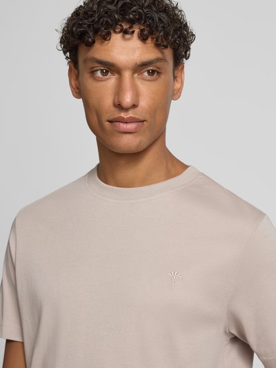 Męski model nosi T-Shirt mit Logo-Stitching Modell 'Priamo' von JOOP! Collection z czystej bawełny, krój regular fit, jasny beż, zbliżenie na górną część ciała.