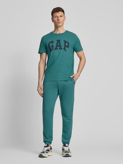 Männermodel trägt Sweatpants mit elastischem Bund von GAP in Blaugrün, Baumwoll-Mix, Regular-Fit, Gesäßtasche, Ganzkörperansicht von vorne.