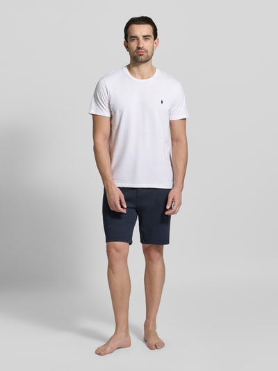 Männermodel trägt T-Shirt mit Logo-Stitching von Polo Ralph Lauren in Weiß, reine Baumwolle, gerade Passform, Ganzkörperansicht von vorne.