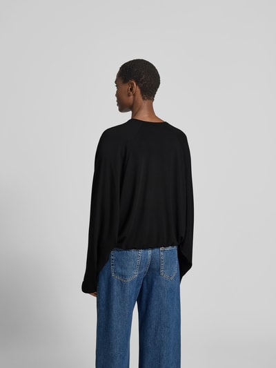 Frauenmodel trägt Oversized Cardigan aus Lyocell-Mix von black palms in Schwarz mit elastischen Abschlüssen, Rückenlänge 58 cm, Ganzkörperansicht Rückansicht.