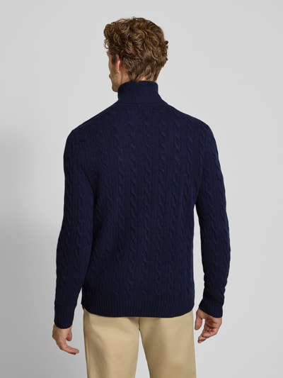 Männermodel trägt dunkelblauen Slim Fit Pullover aus Woll-Kaschmir-Mix von Polo Ralph Lauren, Struktur Zopfmuster, Ganzkörperansicht Rückansicht.