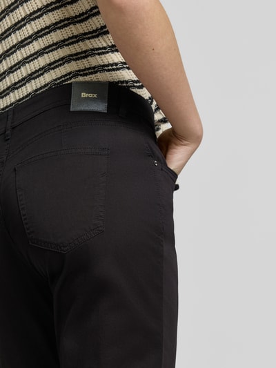Frauenmodel trägt Hose in verkürzter Passform Modell 'Mary' von Brax, Baumwoll-Mix mit Lyocell, Detailaufnahme Rückansicht.