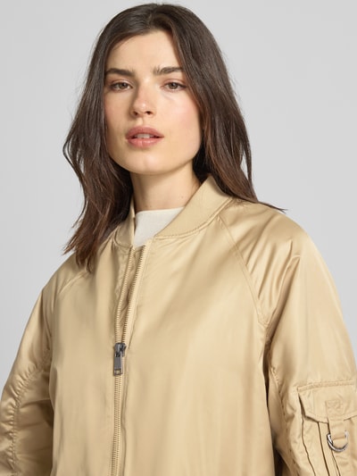 Vrouwenmodel draagt Regular Fit jack met opstaande kraag model 'Ali' van Beaumont Amsterdam in beige met tweewegritssluiting, plooien, elastische mouwboorden, steekzakken, ruglengte 97 cm, schouderbreedte 47 cm, borstwijdte 55 cm, mouwlengte 60 cm, Nahaufnahme Oberkörper.