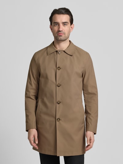 Männermodel trägt Mantel mit Knopfleiste von MCNEAL in Beige mit Kentkragen und Eingrifftaschen, lockerer Schnitt, Ganzkörperansicht von vorne.