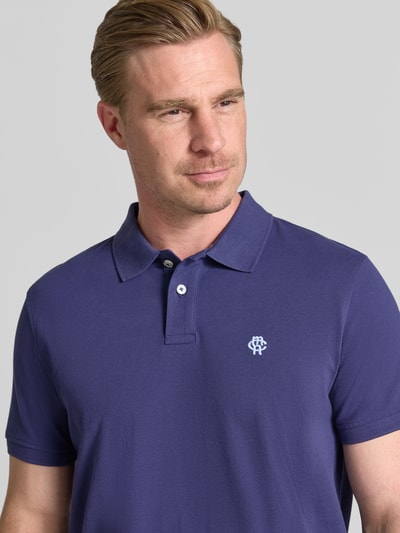 Męski model nosi Regular Fit Poloshirt mit Label-Stitching von MCNEAL z bawełny, listwa guzikowa, długość tyłu 70 cm w rozmiarze M, zbliżenie na górną część ciała