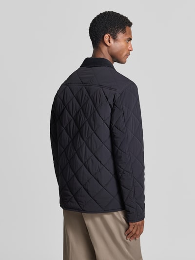 Männermodel trägt Regular Fit Jacke in Stepp-Optik Modell 'Rapid' von CINQUE, schwarze Rauten, elastisches Material, Ganzkörperansicht Rückansicht.