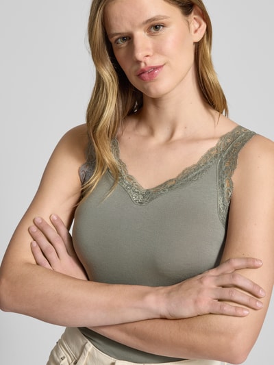 Frauenmodel trägt Slim Fit Tank Top aus Viskose-Mix Modell 'BARBERA LACE' von Pieces, unifarben, breite Träger, Nahaufnahme Oberkörper.