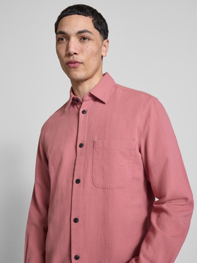 Männermodel trägt Regular Fit Freizeithemd aus reiner Baumwolle von Marc O'Polo Denim in Altrosa, Strukturmuster, Nahaufnahme Oberkörper.