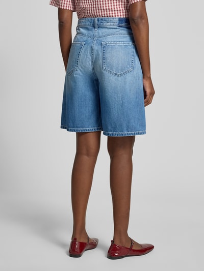 Frauenmodel trägt Loose Fit Jeansshorts aus reiner Baumwolle Modell 'ELIN' von Cambio, Denim-Optik, mit Nieten, Label-Print, seitliche Eingrifftaschen und Gesäßtaschen, Knopf und verdeckter Reißverschluss, hellblaue Farbe, Ganzkörperansicht Rückansicht.