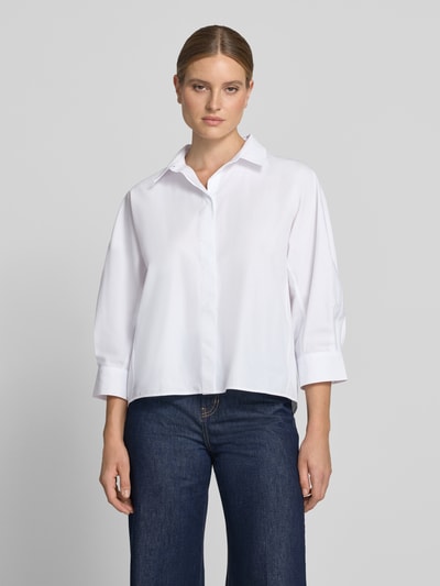 Vrouwenmodel draagt witte Hemdbluse met Stehkragen Modell 'Zelma' van someday, pure katoen, loose fit, knoopsluiting, 3/4-mouw, voorkant volledig lichaam.