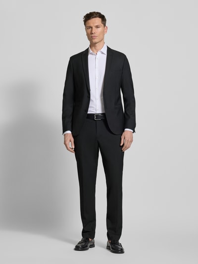 Männermodel trägt Regular Fit Sakko mit Woll-Anteil Modell 'Irving' von Drykorn in Schwarz, Reverskragen, Doppelknopfleiste, Paspeltaschen, gerade Struktur, Ganzkörperansicht von vorne.